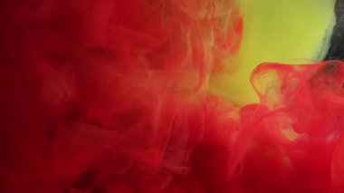 Sis sıvısı. Renk bulanıklığı. Kırmızı dumanlı boya, sarı suda pürüzsüz kıvrımlar oluşturur. Parlak suluboya damla pigmentleri soyut arkaplan karıştırılıyor.