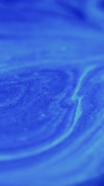 Dikey video. Mürekkep hareketi. Parıltı emülsiyonu. Odaklanmamış mavi sıvı şerit dalgalar gök mavisi karışımı, soyut, parıldayan sanat dokusu, ışıl ışıl arka plan..