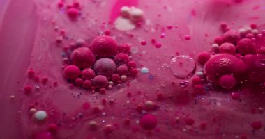 Boya jeli. Yağ kabarcıkları. Pembe pigment topları saydam bulanık sanat sıvısı mermer içinde yüzüyor. Titreyen su, soyut arka plan yüzeyi..