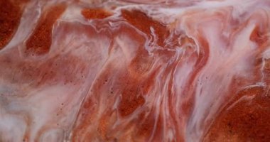 Mermer akışı. Parlak mürekkep. Odaklanmamış renkli parlak toz cilası parçacıkları soyut arkaplanı harmanlıyor. Turuncu bakır beyaz sıvı pigment dökülüyor.