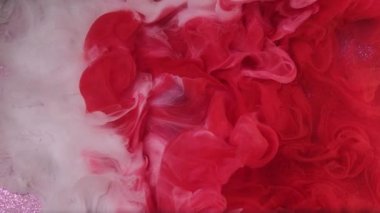 Mürekkep suyu. Sıvı karışımı. Odaklanmamış kırmızı beyaz bulanık bulut buharı parıldayan parlak boya akışı soyut mor parıldayan sanat arka planında noel topu.