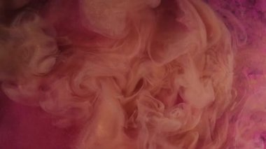 Sis dumanı. Köpüklü su. Odaklanmamış turuncu renkli, parlayan mürekkep deseni soyut pembe sanat eserlerinin üzerine akmaktadır..