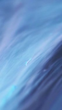 Dikey video. Parıldayan duman. Işıldayan akış. Emülsiyon mavisi boya. Lavanta karışımı renk hareketi sıvı sihirli soyut ışıltı arkaplan tasarımı.