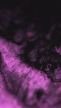 Dikey video. Sıvı büyüsü. Sıvı boya karışımı akar. Pembe pigment sıçrayan dalga hareketi soyut mor doku yaratıcı arkaplan.