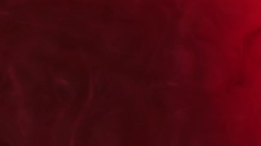 Kırmızı akış. Odaklanamayan akış. Bulutlu renkli sıvı dalgalanıyor. Esrarengiz boya bukleleriyle gizemli ve karanlık bir arka plan..