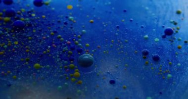Mavi akış. Kabarcık emülsiyonu. Parlayan suda yüzen çok renkli akrilik küreler. Soyut arkaplanda mürekkep damlası karışımı.