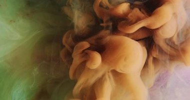 Renkli duman bombası. Parlak mürekkep suyu. Turuncu yeşil buhar, pembe parıldayan parçacıklar dokusunun soyut sanat arkaplanındaki akış hareketini sıçratır.