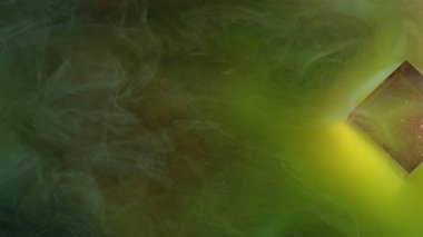 Renkli akış. Dalgalı sis. Dekoratif cam küpün etrafında boyalı suyun hareketi. Puslu, yeşil, parlak mürekkep arkaplanının bulanık, yumuşak akışı.