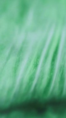 Dikey video. Köpüklü duman bulutu. Parıldayan yeşil akış. Renkli boya karışımı dalga hareketi büyüleyici soyut sanat arkaplanı.