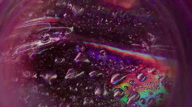 Gökkuşağı suyu. Bulanık renkli damlacık. Odaksız sızıntı, yeşil ışınlar, kabarcıklar, ışınlar, mercek parlamaları, soyut sanat ışığı arka planı..