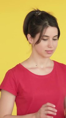 Dikey video. Alışveriş fiyaskosu. Hayal kırıklığına uğramış, kayıp kadın çantaları sarı boş alanda izole edilmiş..