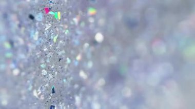 Dikey video. Sıvı sim dökülmüş. Parlak jel dokusu. Odaklanmamış holografik payet parçacıkları şeffaf ıslak parlatıcı sıvı akışı soyut sanat arkaplanı ve bokeh ışıkları.