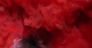 Duman dalgası. Sanat sıvısı. Siyah su yüzeyinde kırmızı parıldayan boya karışımı patlaması. Soyut duman girdabı dağılmış arka plan.