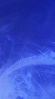 Dikey video. Bulanık sis. Mürekkep suyu karışımı. Odaklanmamış mavi renk parlayan duman dokusu kara soyut sanat arka planında dönen hareket..