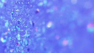 Dikey video. Parlak boya akışı. Islak sim dokusu. Bulanık mavi renkli parlak yanardöner parçacıklar boya sıvı jel hareketli soyut sanat arka planı ile bokeh ışıkları.
