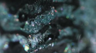 Dikey video. Parıldayan sıvı dökülmüş. Işıldayan boya. Bulanık deniz mavisi siyah holografik parçacıklar yağ emülsiyon damla hareket soyut sanat arka planı Bokeh ışıkları ile.