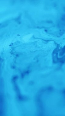 Dikey video. Akrilik dalga. Boya sıçraması. Bulanık mavi renk parlayan nemli emülsiyon sızıntısı harmanlanmış hareket lekesi dokusu soyut sanat arkaplanı.