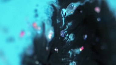 Dikey video. Köpüklü boya damlası. Parlak sıvı dokusu. Bulanık mavi renk parlak pullu tanecikler akrilik mürekkep karışımı sıvı emülsiyon hareketli soyut sanat arka planı.
