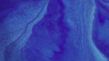 Bulanık parıltı sıvısı. Su parıldıyor. Işıl ışıl beyaz, yanıp sönen sıvı boya mürekkebi parlak toz, soyut bokeh ışık arka planında hareket ediyor..