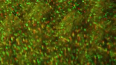 Pırıl pırıl bir üçgen. Konfeti titriyor. Sarı mavi çok renkli noktalar ışıldayan parçacıklar Bokeh ışığı soyut arkaplan üzerinde hareket ediyor.