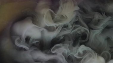 Sis akışı. Duman karışımı. Gri toz dumanı mürekkebi suya düşer. Gizemli kül bulutu çözünmüş siyah arkaplan üzerine soyut doku sıçrattı.