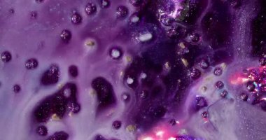 Parıltı karışımı. Akrilik sıvı. Soyut sanat arka planına yayılan kimyasal suda parlayan mor altın rengi..