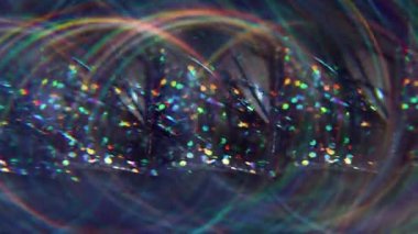 Parıltılı kıvılcımlar. Odaklanamayan gökkuşağı yansıması. Mor sarı çok renkli parçacıklar yanıp sönen ışın titreşimleri soyut bokeh ışık arkaplanı üzerinde hareket ediyor.