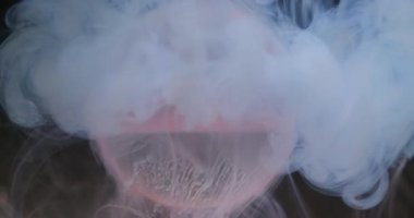 Sis boyası. Küre damlıyor. Odaklanmamış pembe renk su dokusu sıvı buhar dalgası soyut sanat üzerine yayılıyor koyu siyah arkaplan.