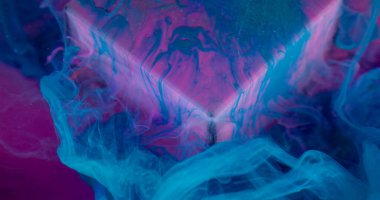 Mürekkep karışımı. Sanat dumanı. Mavi renk boya akışı pembe mor floresan cam küp yüzeyine yayılıyor. Yağlı su pigmenti soyut arkaplan bulanıklığı.