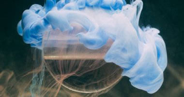 Sis boyası. Küre damlıyor. Odaklanamayan mavi renkli su dokusu sıvı buhar dalgası soyut sanat üzerine yayılıyor koyu siyah arkaplan.