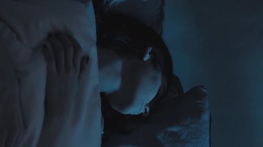 Dikey video. Kabus korkusu. Kötü bir rüya. Uyku bozukluğu. Karanlik yatak odasinda karabasandan uyanan huzursuz bir kadin..
