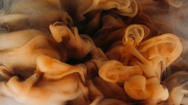 Sis akışı. Duman karışımı. Kahverengi girdap dumanı suya mürekkep damlatıyor. Mistik sıvı bulut esintisi soyut odaklanmış arkaplanı sıçratır.