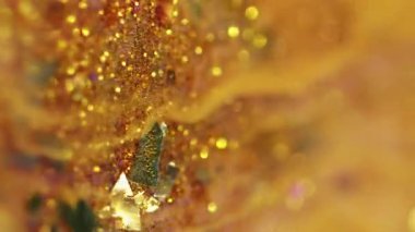 Dikey video. Parlak boya dökülmüş. Sıvı sim akışı. Bulanık altın rengi metalik pullu parçacıklar ıslak akrilik akrilik akışkan dalga hareketi soyut sanat arka planı ve bokeh ışıkları.