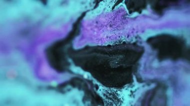 Dikey video. Akışkan sanat. Parıltılı boya döküldü. Odaklanmamış mavi mor renkli parıldayan tahıl tanecikleri akrilik sıvı mürekkep karışımı hareketli soyut arka plan baloncukları.