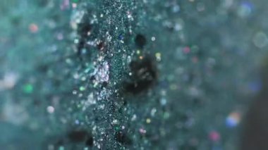 Dikey video. Sıvı pırıltılı boya. Islak sim damlası. Bulanık deniz mavisi siyah holografik pullu parçacıklar parlak jel sıvısı mürekkep sızıntısı soyut sanat arka planı ve bokeh ışıkları.