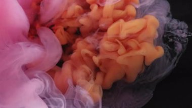 Sis akışı. Duman karışımı. Suya turuncu pembe duman damlası patlaması. Renk bulutu üfleme bulanıklığı siyah arkaplanda soyut doku sıçraması.
