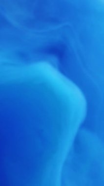 Dikey video. Odaklanmamış duman dokusu. Buhar borusu. Bulanık mavi renk boya su sıçrıyor bulut dalgası hareket fantazisi soyut sanat arka planı.