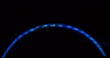 Neon kemeri. Açık gökkuşağı. Yağlı boya mavi parlaklık siyah sıvı arka planda yuvarlak lens parıltısı. Renkli benzin karışımı holografik ışın akışı.