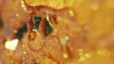 Dikey video. Köpüklü yağ damlası. Parıltılı boya döküldü. Bulanık altın rengi parlak metalik pullu parçacıklar mürekkep parlatıcısı sıvı hareket soyut sanat arkaplanı ve bokeh ışıkları.