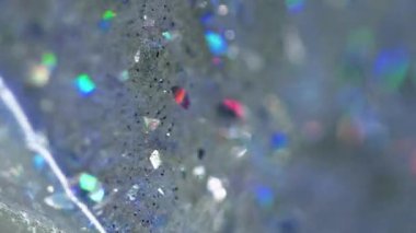 Dikey video. Parlak sıvı damlası. Parlak doku. Bulanık holografik parlak pullu parçacıklar şeffaf su jeli sıvı akışı soyut sanat arka planı ve bokeh ışıkları.