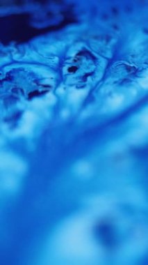 Dikey video. Mürekkep döküldü. Sıvı karışımı. Odaklanmamış mavi renk ıslak akrilik emülsiyon karışık dalga akış mermer desen soyut sanat arka planı.