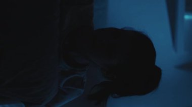 Dikey video. Taşınabilir endişe. Gece hüsranı. Kızgın kadın, karanlık yatak odasında telefonunu fırlatıp yastığını yumrukluyor..