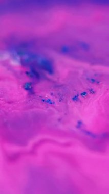 Dikey video. Mürekkep dalgası. Parıldayan sıvı dökülmüş. Odaklanmamış pembe mavi altın rengi ışıl ışıl desen sıvı akış hareketi soyut sanat arkaplanı.