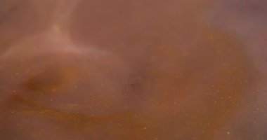 Parçacık suyu. Köpüklü boya. Soyut sanat arka planında çözünmüş sarı turuncu renkli kimyasal su sim sıvısı.