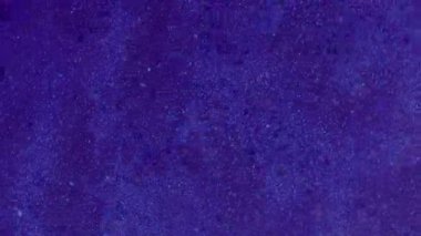 Görüntü pırıltısı. Toz dokusu. Beyaz renkli ışıldayan parçacıklar soyut koyu mavi arkaplanda dönen parlak sisli boya..