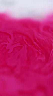 Dikey video. Mürekkep dalgası. Akrilik sıvı. Odaklanmamış morumsu pembe renk boyalı su emülsiyon akışı hareketli yaratıcı soyut sanat arkaplanı yayıyor.
