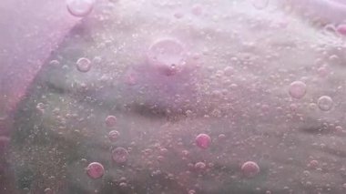 Kabarcık boyası. Arka planı bırak. Su sıvısı esansında çözünmüş pembe renk mürekkebi yağ dokusu parlak boncuk soyut sanat üzerine dökülüyor..