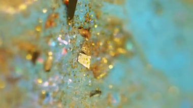 Dikey video. Parıltılı boya karışımı. Işıldayan sıvı doku. Bulanık mavi altın rengi parlak pullu parçacıklar akrilik akışkan mürekkep akışı soyut sanat arka planında Bokeh ışıkları.