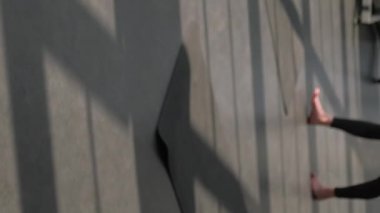 Dikey video. Meditasyon eğitimi. Yoga dersi. Farkındalık pratiği. Kadın eğitmen derse grup elemanlarından başlar. Spor salonundaki spor paspasına lotus pozu verir..