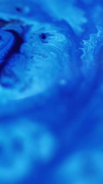 Dikey video. Boya sıçraması. Sıvı dökülmesi. Odaklanmamış mavi renk emülsiyon dokusu akrilik sıvı karışık dalga hareketi soyut sanat arkaplanı.